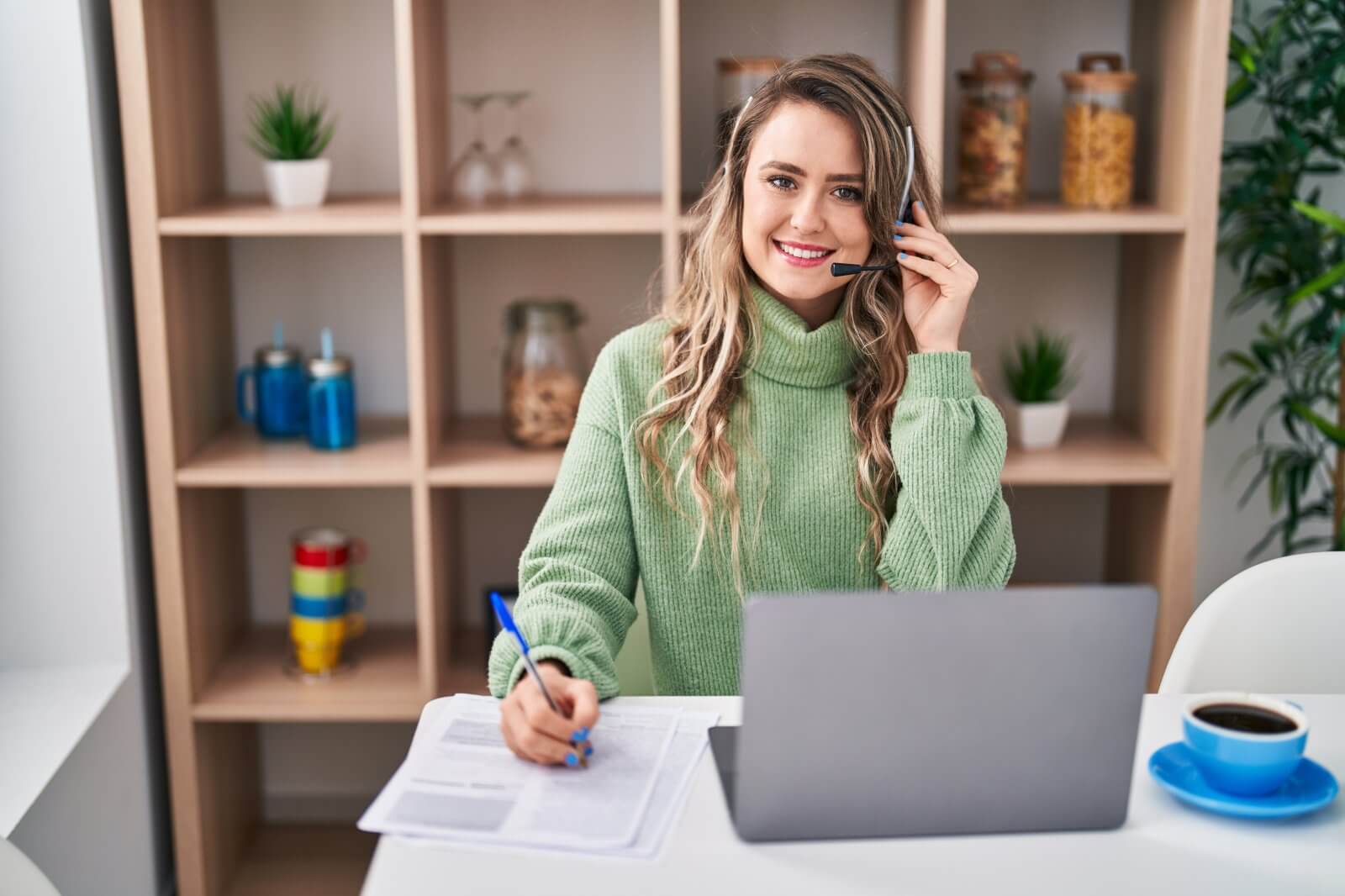 Woman wearing a headset while writing on a document